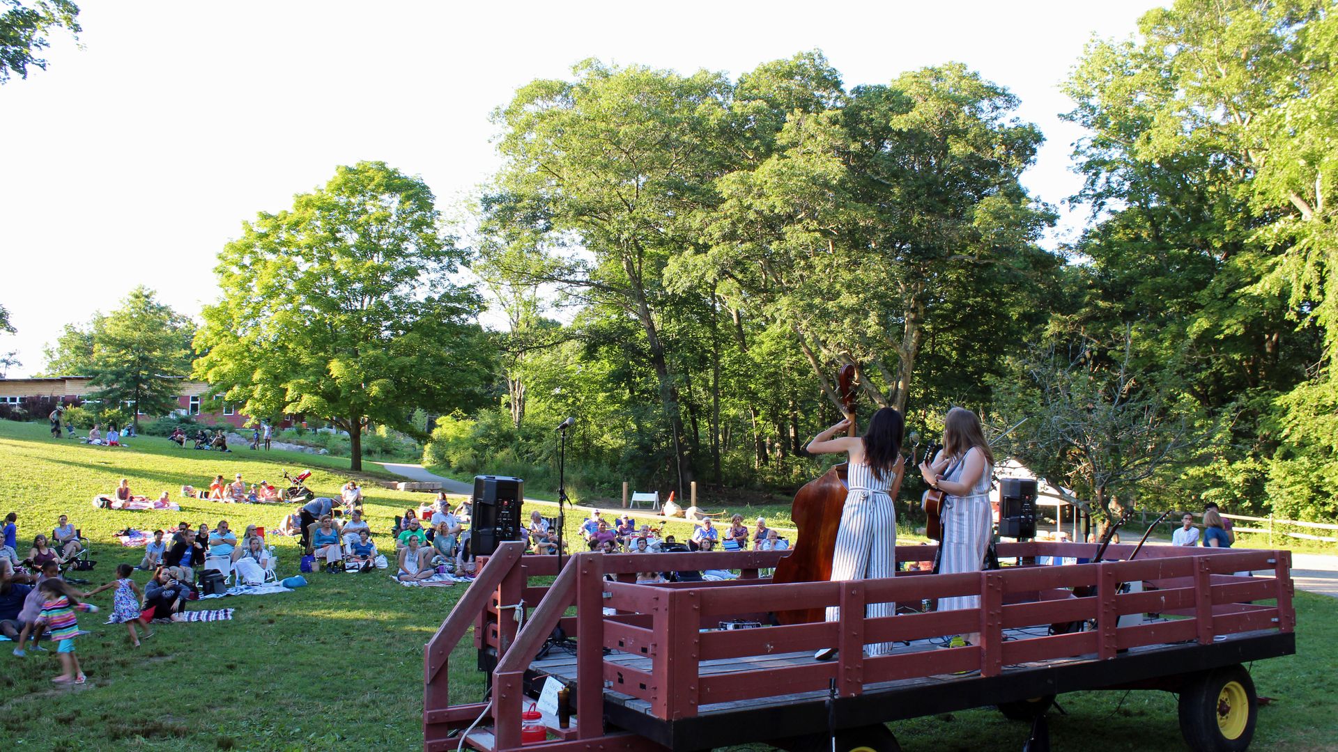 Family walking a lantern‑lit path at Drumlin Farm, warm evening glow